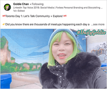 Esta é uma captura de tela de um vídeo do LinkedIn no qual Goldie Chan documenta suas viagens. O texto acima do vídeo diz “Dia 1 de Toronto: Vamos conversar sobre a comunidade + Explorar! Você sabia que milhares de encontros acontecem todos os dias a... ver mais". O vídeo mostra Goldie em frente a um mural em uma parede de tijolos. O mural mostra um céu azul brilhante e falésias marrons cobertas por uma vegetação brilhante. Goldie aparece do peito para cima. Ela é uma mulher asiática com cabelo verde. Ela está usando um boné de malha azul e parka preta com gola peluda. No canto superior direito do vídeo, #DailyGoldie aparece em texto pêssego com um contorno verde.