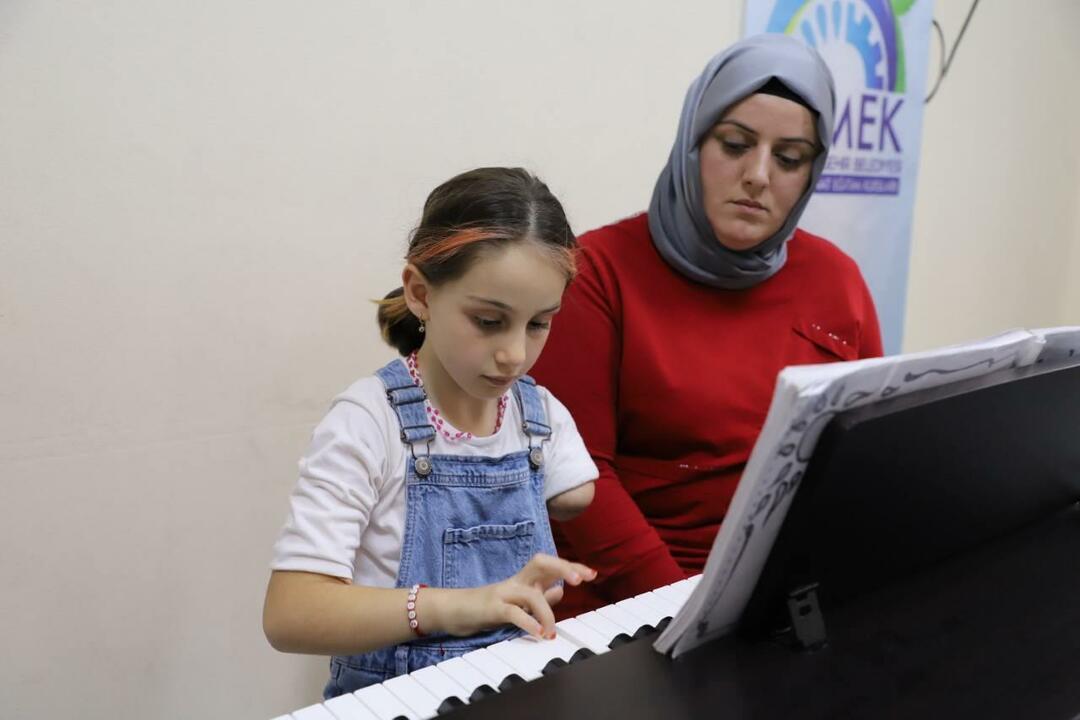 Zeynep, que não nasceu com o braço esquerdo, é sustentada pela mãe.
