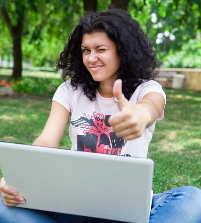 Menina no laptop no parque