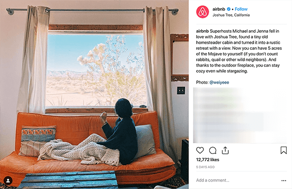 Esta é uma captura de tela de uma postagem do Instagram do Airbnb. Conta a história de um casal que hospeda pessoas em sua casa através do Airbnb. Na foto, alguém está sentado em um sofá laranja sob uma manta de malha bege e olha pela janela para uma paisagem do deserto. Melissa Cassera diz que essas histórias são um exemplo de uma empresa que usa a trama da superação do monstro em seu marketing de mídia social.